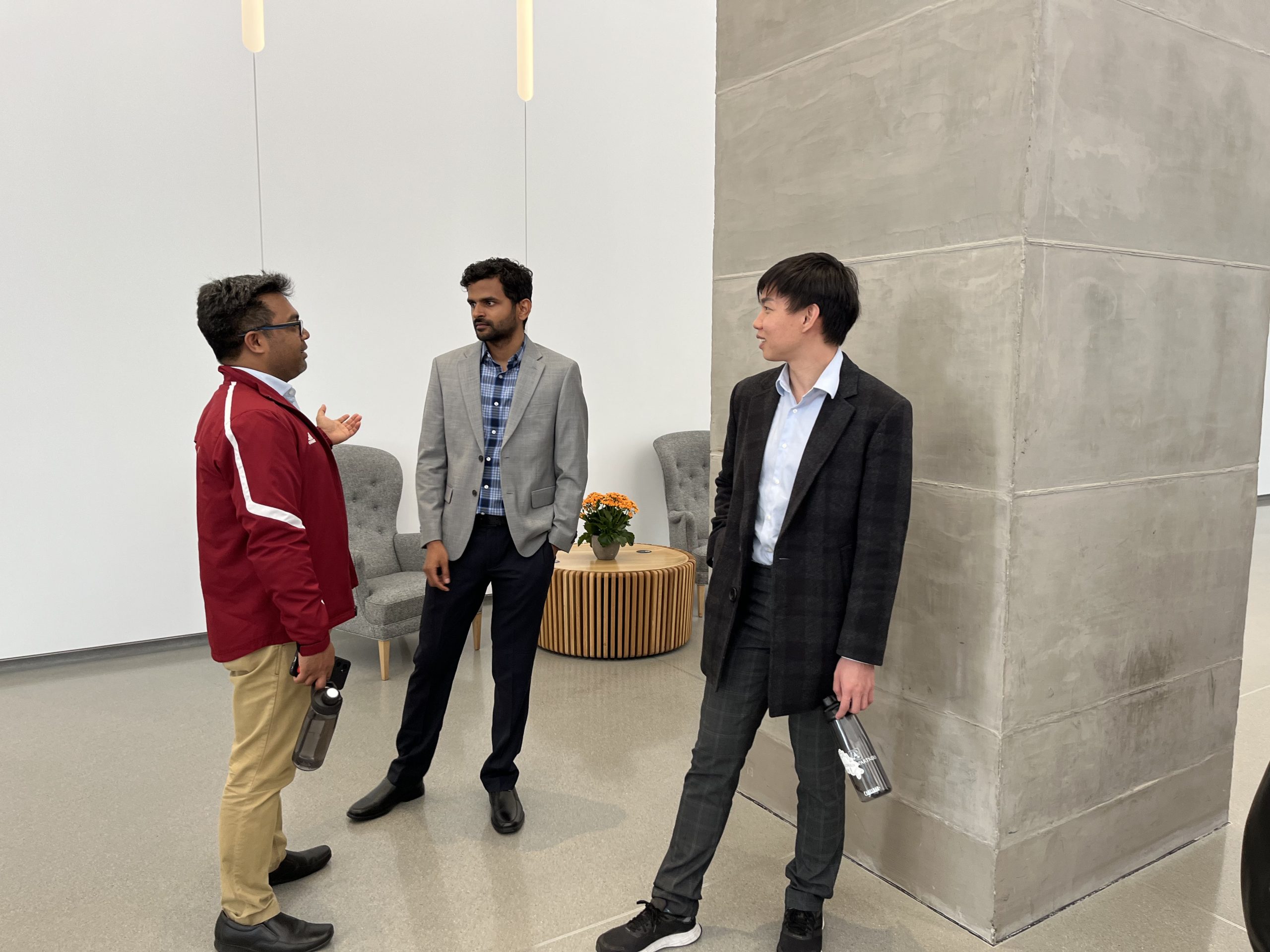 Three men standing and talking.
